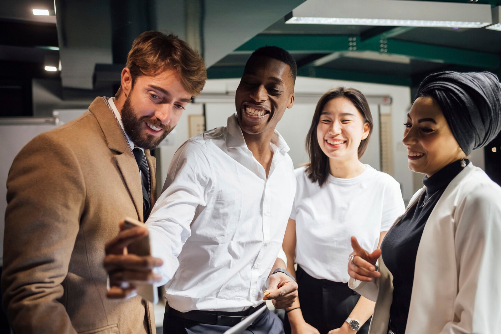 Business colleagues smiling together and looking at a phone